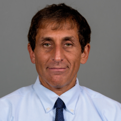 Donald Siegel headshot - medium-skinned man, brown hair, blue collared shirt