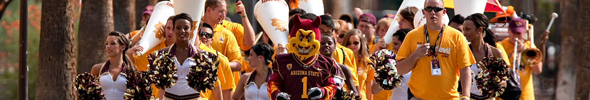 ASU students, marching band members, cheerleaders, and Sparky the Sun Devil walking down Palm Walk 