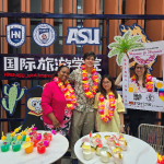 Faculty and students posing with food and flowers