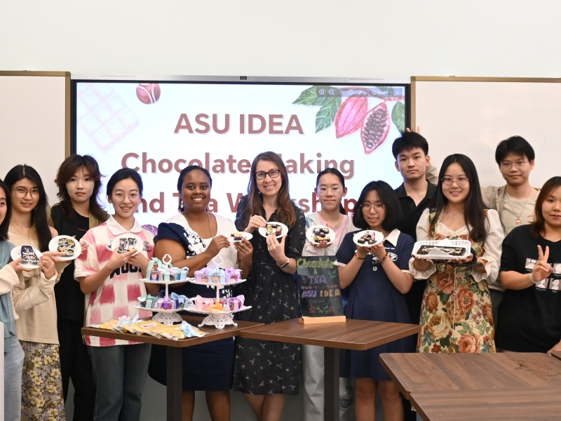 Group picture of HAIC students holding up chocolate and tea